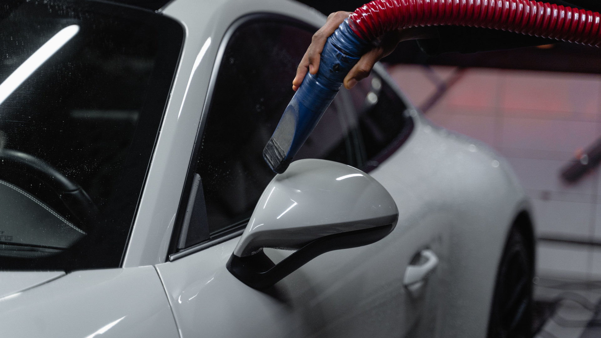 A white sports car receiving professional exterior detailing